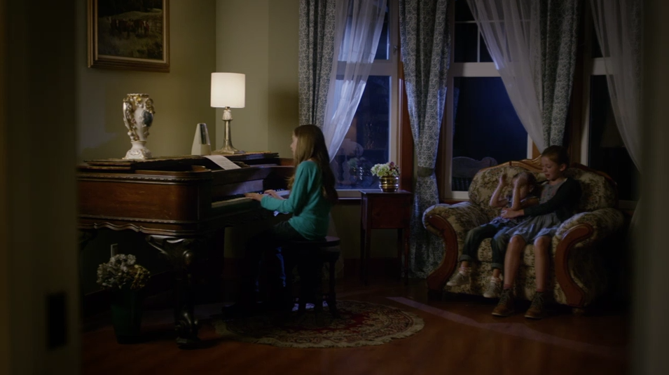 Mary Lou, Bunny and Peggy sit around the piano. 
